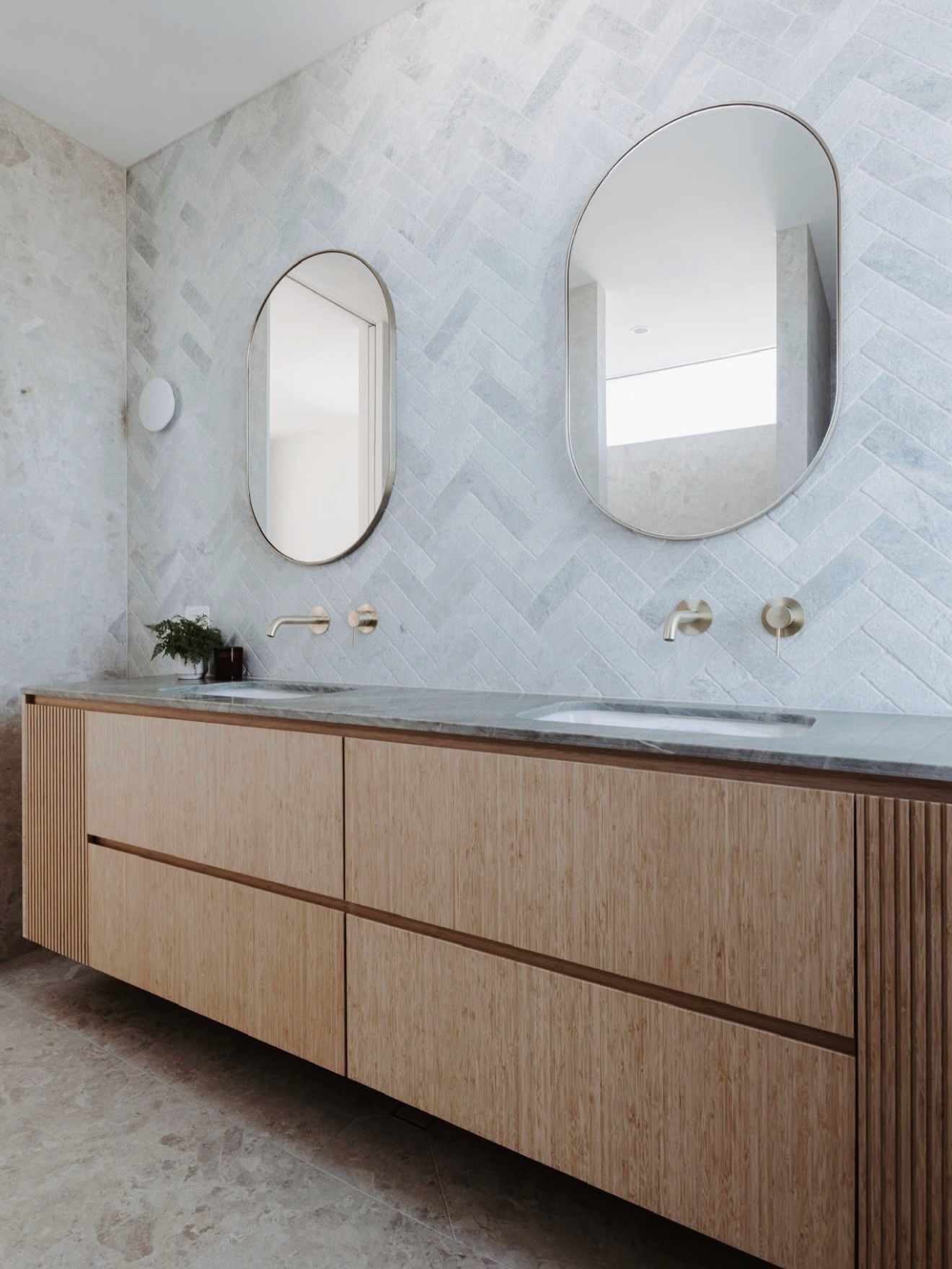 Bamboo vanity and curved mirrors in a Byron Bay bathroom